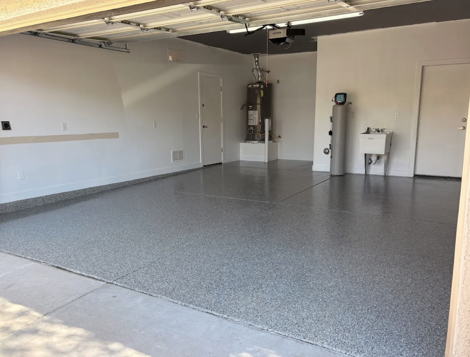 Large garage interior with smooth gray flake floor coating installed wall to wall